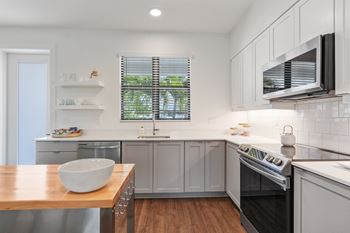 A kitchen with stainless steel appliances and a wooden table